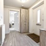 Modern hallway with wooden flooring and cupboard.