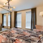Stylish bedroom with patterned bedding and modern lighting.