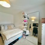 Modern bedroom with desk and large mirror.