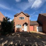 Two-storey red brick house with front driveway.
