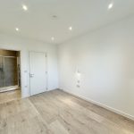 Empty room with wooden floor and en-suite bathroom.