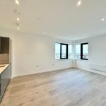 Modern open-plan kitchen and living room with city view.