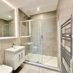 Modern bathroom with shower and heated towel rail.