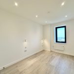 Empty room with wooden floor and window view.