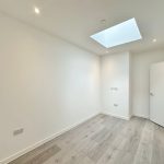 Minimalistic room with skylight and wooden floor