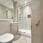 Modern bathroom with shower, toilet, and sink.