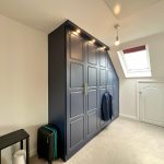 Modern attic room with wardrobe and skylight window.
