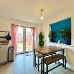 Bright kitchen with dining table and plants.