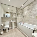 Modern bathroom with bathtub, sink, and toilet.