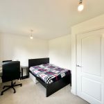 Modern bedroom with desk and bed.