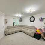 Modern living room with grey sofa and decor items.