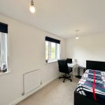 Bright bedroom with desk and bed.
