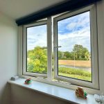 Open window with view of trees and road.