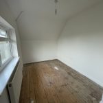 Empty room with wooden floor and window.