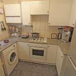 Compact kitchen with appliances and countertops.