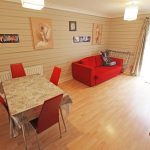Living room with red sofa and dining table.