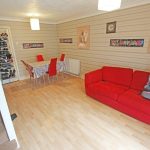 Living room with red sofa and dining table.