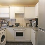Compact kitchen with appliances and utensils displayed.