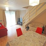 Cosy living room with red sofa and TV.