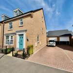 Modern brick house with driveway and blue door.