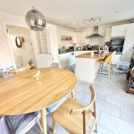 Modern kitchen with wooden dining table and island.