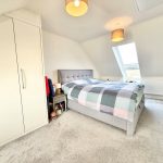 Cosy bedroom with bed, wardrobe, and skylight window.
