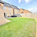 Back garden with lawn and patio area.