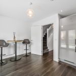 Modern kitchen with bar stools and table.