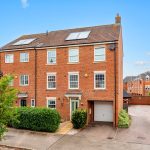 Large red-brick house with driveway and garage.