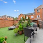Brick courtyard garden with patio furniture and plants.