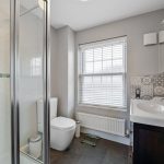 Modern bathroom with shower, sink, and toilet.