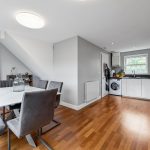 Modern kitchen and dining room with wooden floor.