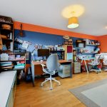 Colourful home office with desks and musical instruments.