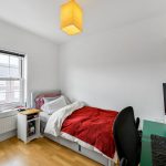 Single bedroom with desk and computer setup.