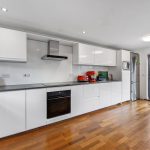 Modern kitchen with white cabinets and garden view