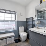 Modern bathroom with grey tiles and window display.