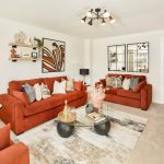 Modern living room with orange sofas and artwork.