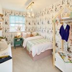 Cosy children’s bedroom with woodland-themed wallpaper.