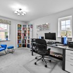 Modern home office with bookshelves and computer desk.