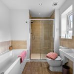 Modern bathroom with tub, shower, and sink.