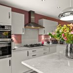 Modern kitchen with flowers on countertop.