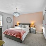 Cosy bedroom with pink and grey decor.