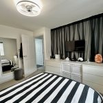 Modern bedroom with monochrome decor and smart furnishings.