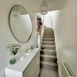 Modern hallway with staircase and mirror