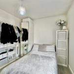 Modern minimalist bedroom with wardrobe and plants.