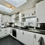 Modern kitchen with white cabinets and appliances.