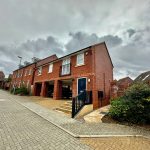 Modern red brick house on cloudy day.