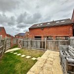 Back garden with patio and overcast sky