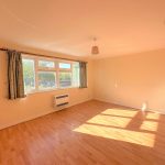 Sunny, empty room with wooden flooring
