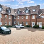 Brick building with cars in courtyard